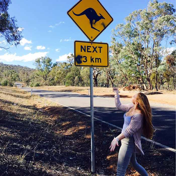 Au pair Nina under a kangaroo road sign
