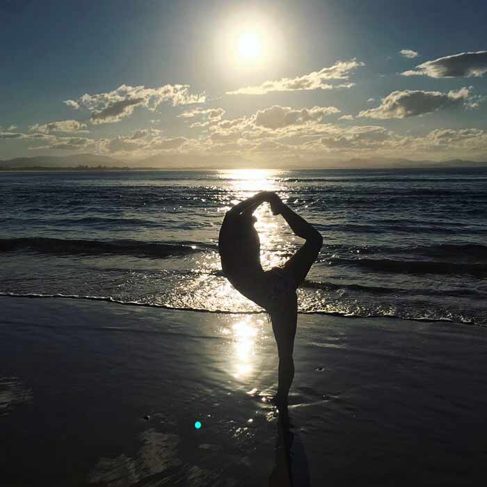 Nina on the beach doing yoga
